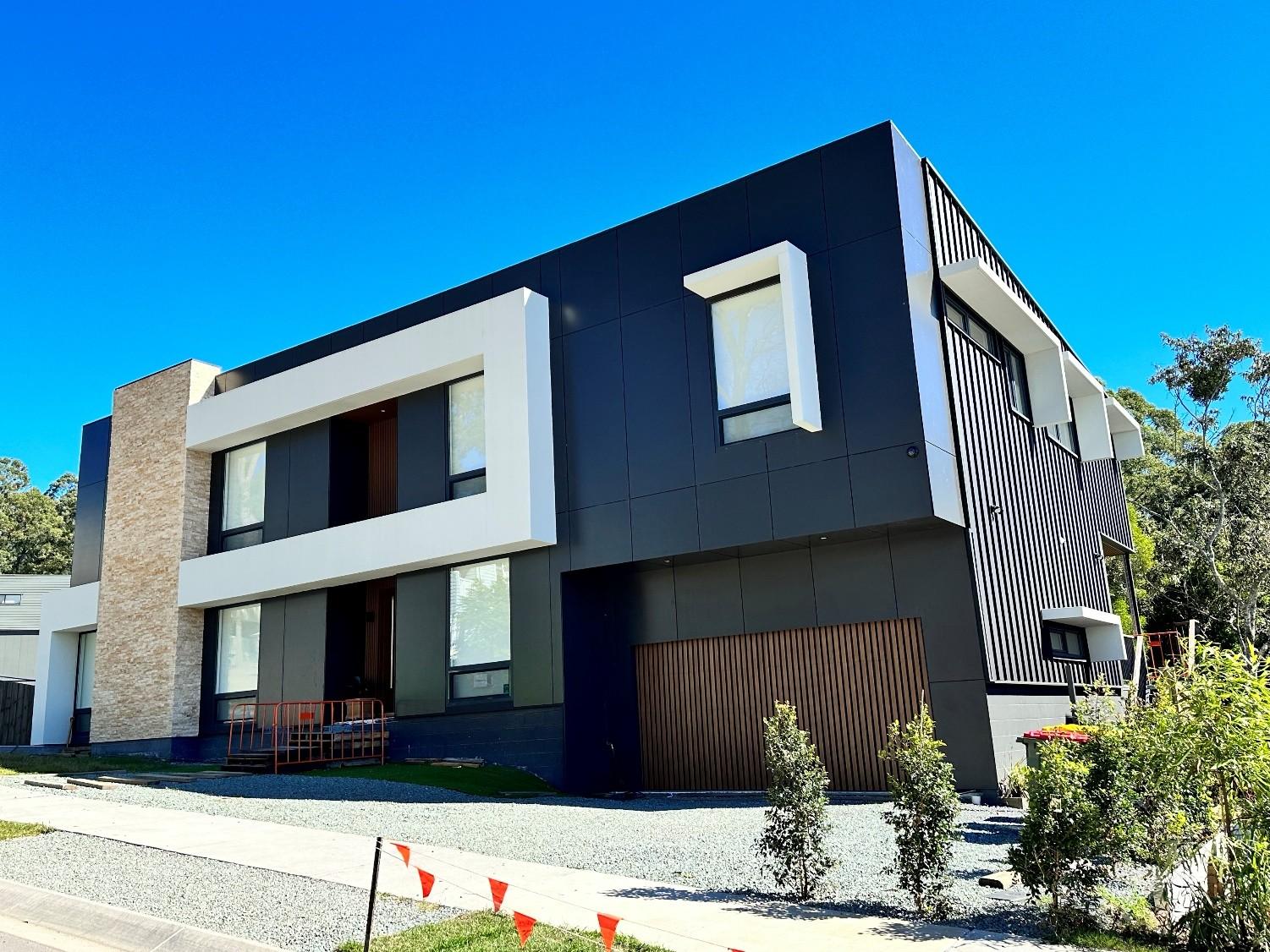 Dark cladding against white render with stone detailing